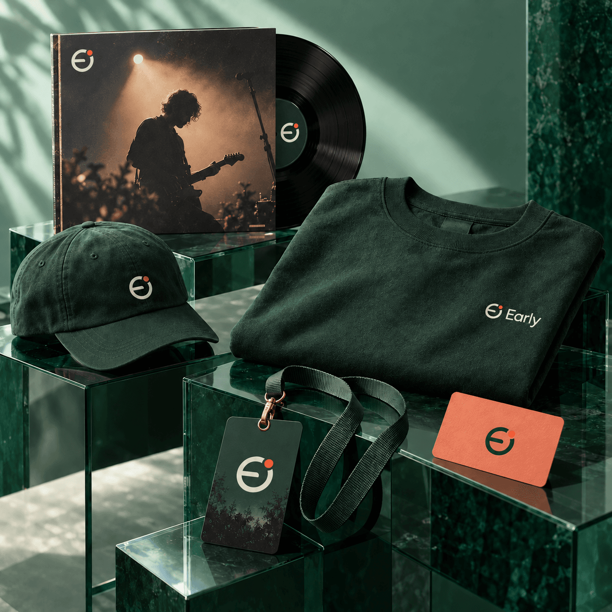 Early merchandise, a vinyl release, and membership passes arranged on emerald glass